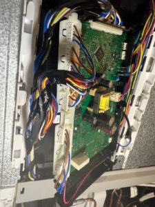 Appliance main control board with wiring harness during repair