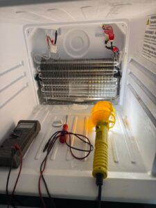 Refrigerator evaporator compartment with meter leads and work light