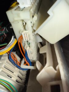 Washer wiring connector block close-up during repair